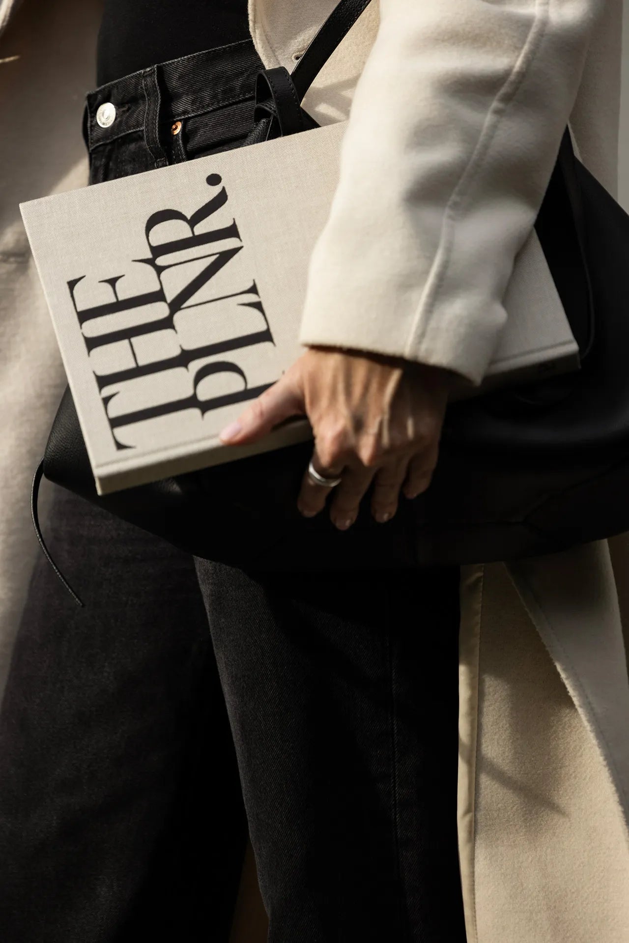 A successful and ambitious woman carrying The PLNR and a leather bag.